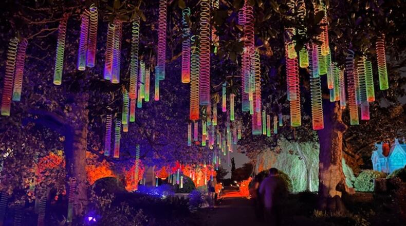 Iluminated rainbow Slinkys hanging from one of Oakland Cemetery's mature trees is a fanciful touch, adding a different dimension to a nighttime art tour of the Victorian burial ground,