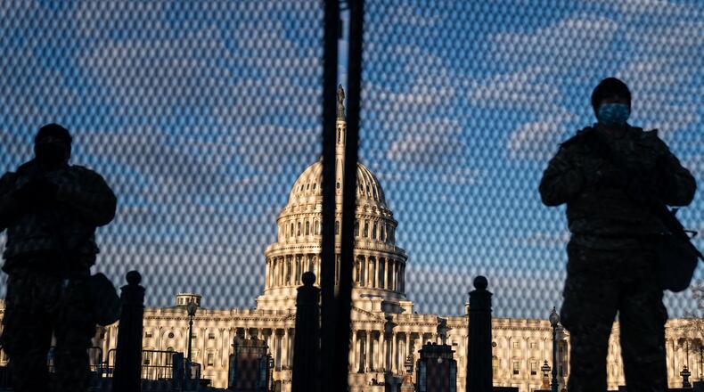 National Guard troops stand behind security fencing with the dome of the U.S. Capitol Building behind them on Jan. 16, in Washington, D.C. After the Jan. 6 riots and security breach at the U.S. Capitol Building, the FBI has warned of additional threats in the nation's capital and across all 50 states. (Kent Nishimura/Los Angeles Times/TNS)