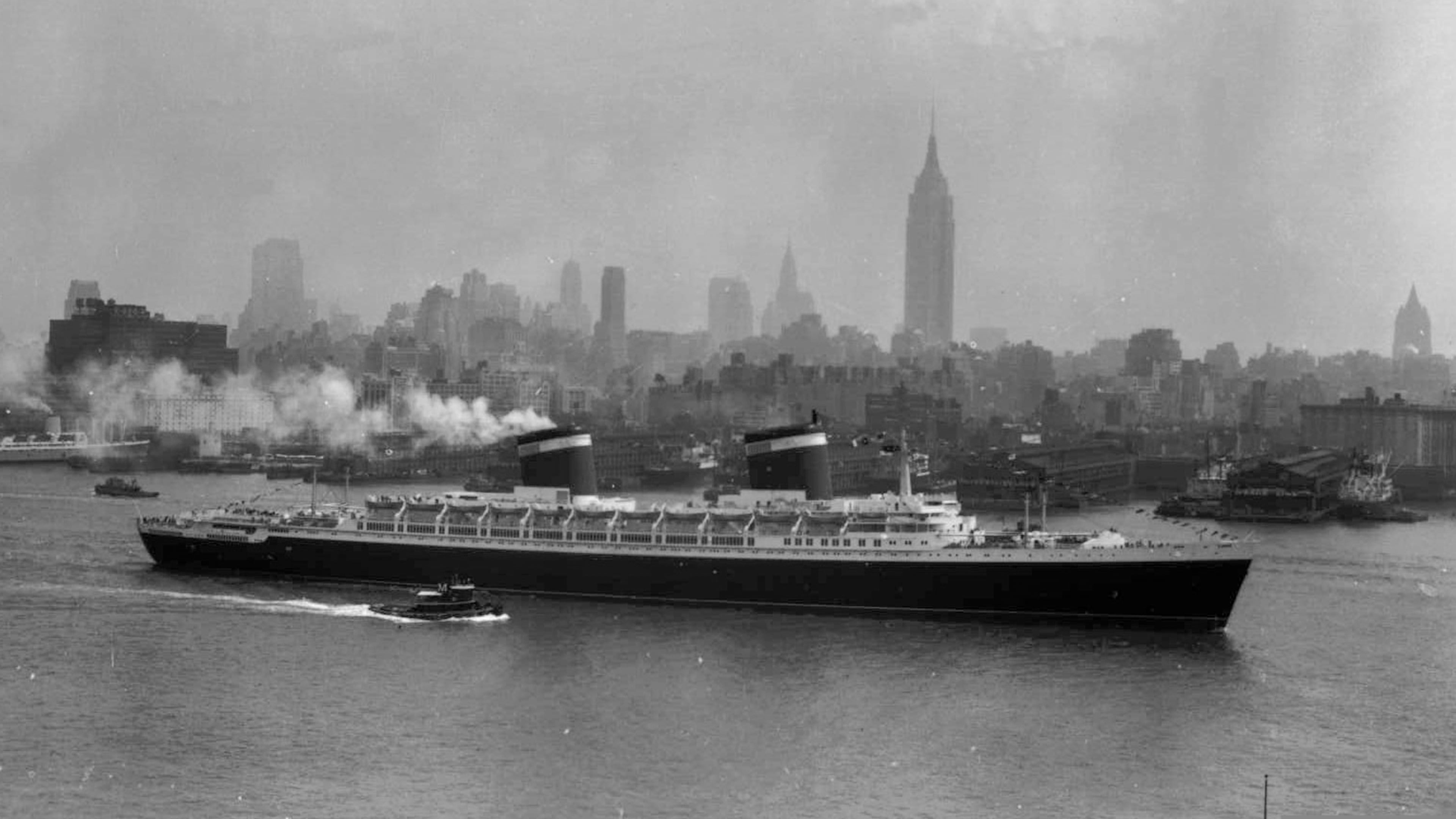 FILE - The SS United States travels along the Hudson River as it begins its first voyage to Europe from New York, July 3, 1952, with the view of the Midtown Manhattan skyline including the Empire State Building at center right. (AP Photo/Jack Harris, File)