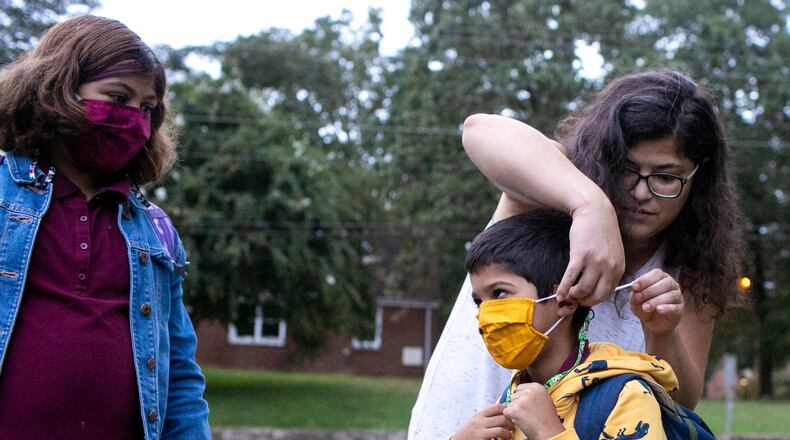 Serene Varghese adjusts her son Omar’s mask while walking to Burgess Elementary School in East Atlanta on Thursday, September 9, 2021. Serene Varghese’s daughter, Dahlia, got Covid-19 during the first week of school about a month ago. (Rebecca Wright for the Atlanta Journal-Constitution)