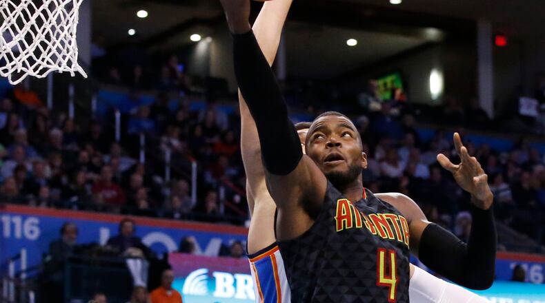 Atlanta Hawks forward Paul Millsap (4) shoots in front of Oklahoma City Thunder center Enes Kanter in the fourth quarter of an NBA basketball game in Oklahoma City, Monday, Dec. 19, 2016. Atlanta won 110-108. (AP Photo/Sue Ogrocki)