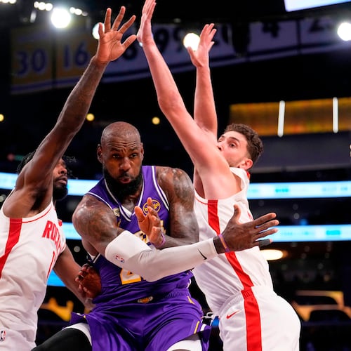 Los Angeles Lakers forward LeBron James, center, passes the ball as Houston Rockets forward Tari Eason, left, and center Alperen Sengun defend during the first half in Game 5 of a first-round NBA playoffs basketball series Wednesday, April 29, 2026, in Los Angeles. (AP Photo/Mark J. Terrill)