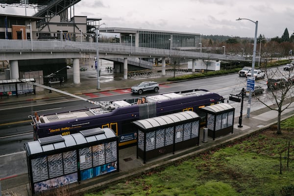 A King County Metro bus stops in Seattle along Montlake Boulevard NE outside of Sound Transit’s University of Washington station in December. (Ramon Dompor for the AJC)