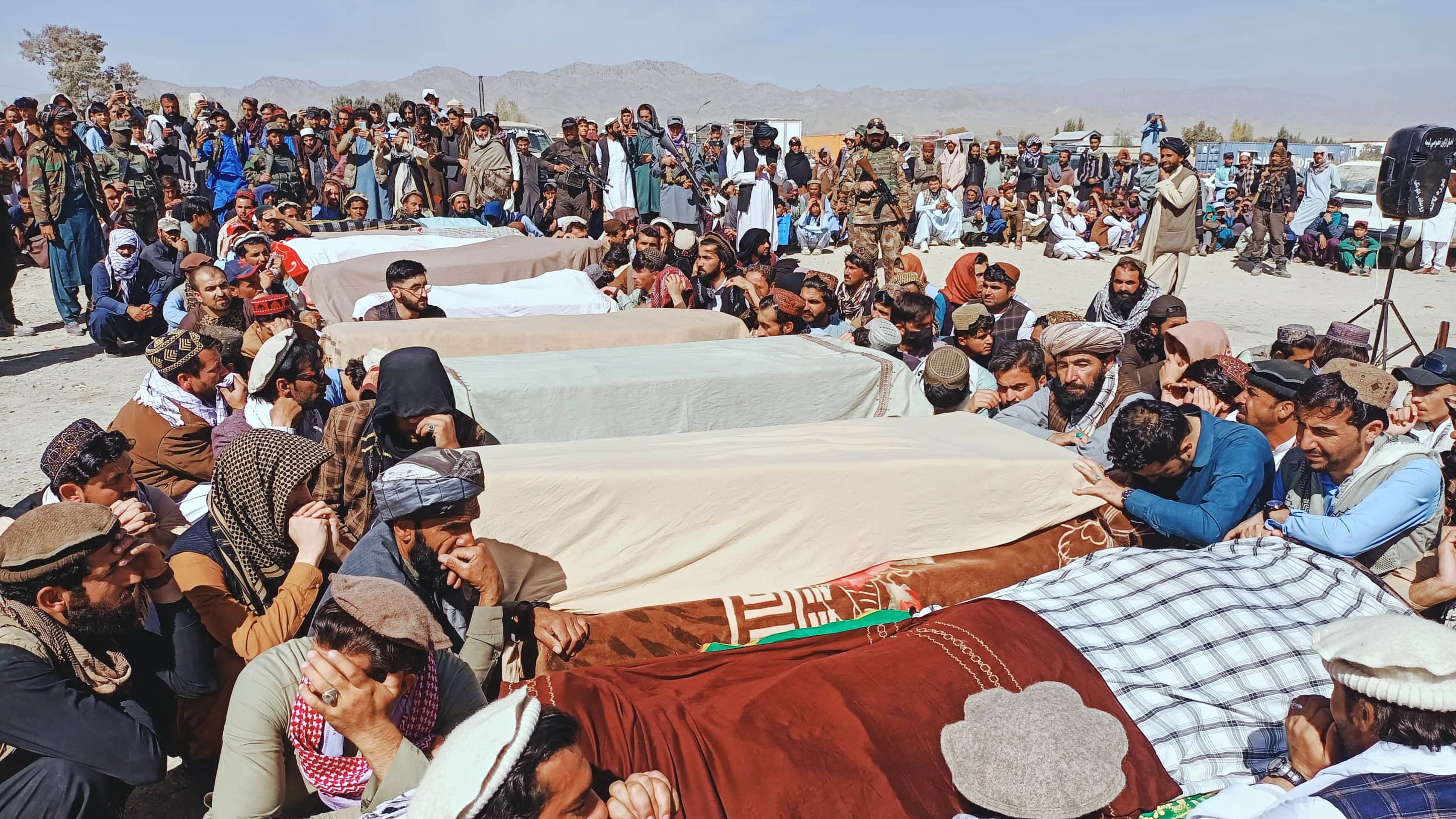 Local residents pray over the bodies of victims of a Pakistani cross-border airstrike, including three local cricketers, during a funeral in the village of Khandaro in the Argun district of Afghanistan's eastern Paktika province, Saturday, Oct. 18, 2025. (AP Photo/Shafiqullah Mashaal)