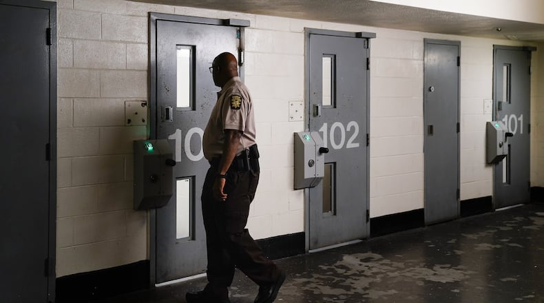 A corrections officer looks in a jail cell during a tour of the Fulton County Jail on Monday, December 9, 2019, in Atlanta. (Elijah Nouvelage/Special to the Atlanta Journal-Constitution)