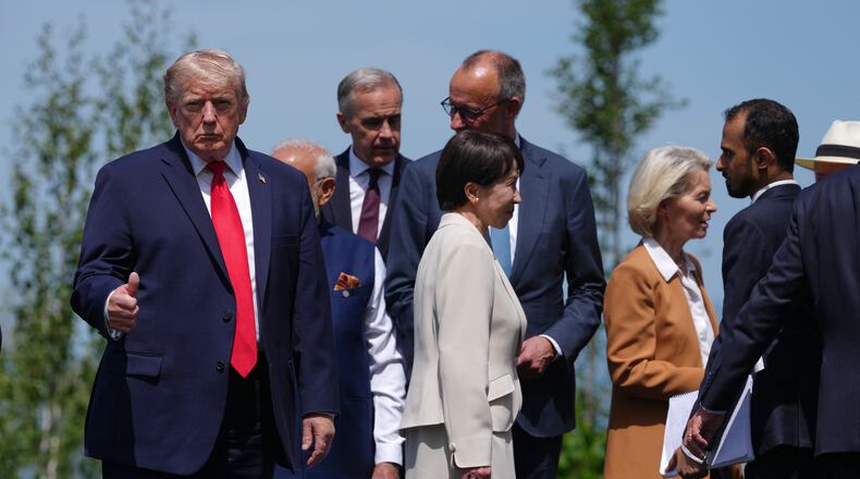 U.S. President Donald Trump, left, gestures prior to a group photo of G7 leaders and invited nations during the G7 summit in Evian-les-Bains, France, Tuesday, June 16, 2026. (AP Photo/Thibault Camus)