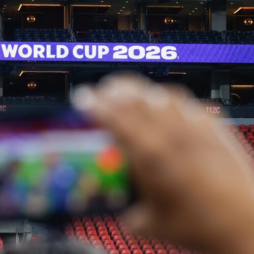 A reporter takes video as a sign for FIFA World Cup is seen at Mercedes-Benz Stadium in Atlanta on May 21, 2026. (Arvin Temkar/AJC)