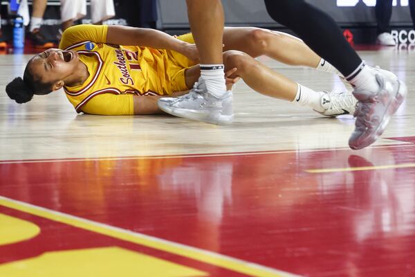 Southern California guard JuJu Watkins (12) reacts on the floor after an injury as Mississippi State guard Chandler Prater watches during the first half in the second round of the NCAA college basketball tournament Monday, March 24, 2025, in Los Angeles. (AP Photo/Jessie Alcheh)