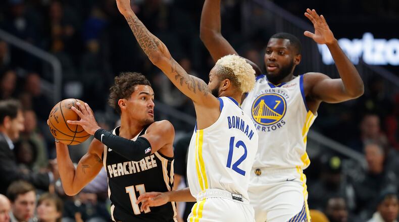 Ky Bowman (12) and Eric Paschall of the Warriors defend Atlanta's Trae Young during Monday's game at State Farm Arena. (Photo by Kevin C. Cox/Getty Images)