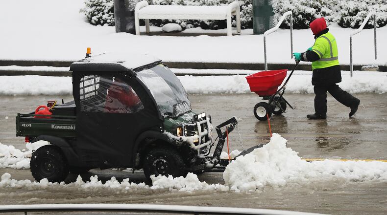 December 9, 2017 Atlanta: A worker spreads salt while a plow works to clear the road in front of the Georgia World Congress Center after a second round of snow fall on Saturday, December 9, 2017, in Atlanta. Curtis Compton/ccompton@ajc.com