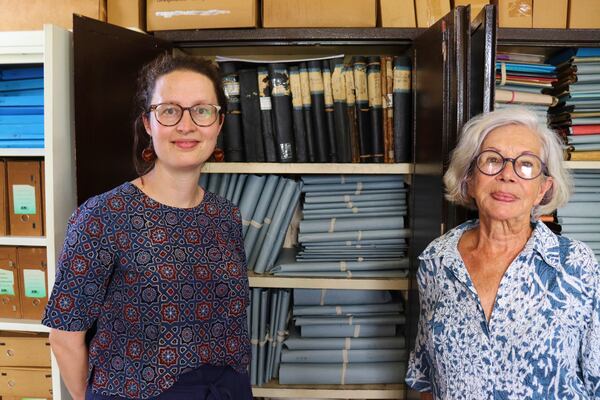 Rosa de Jong, left, and Lilly Duijm pose in front of the boxes of documents from the archive in Paramaribo, Suriname, Friday, May 2, 2025. (AP Photo/Oscar Keur)