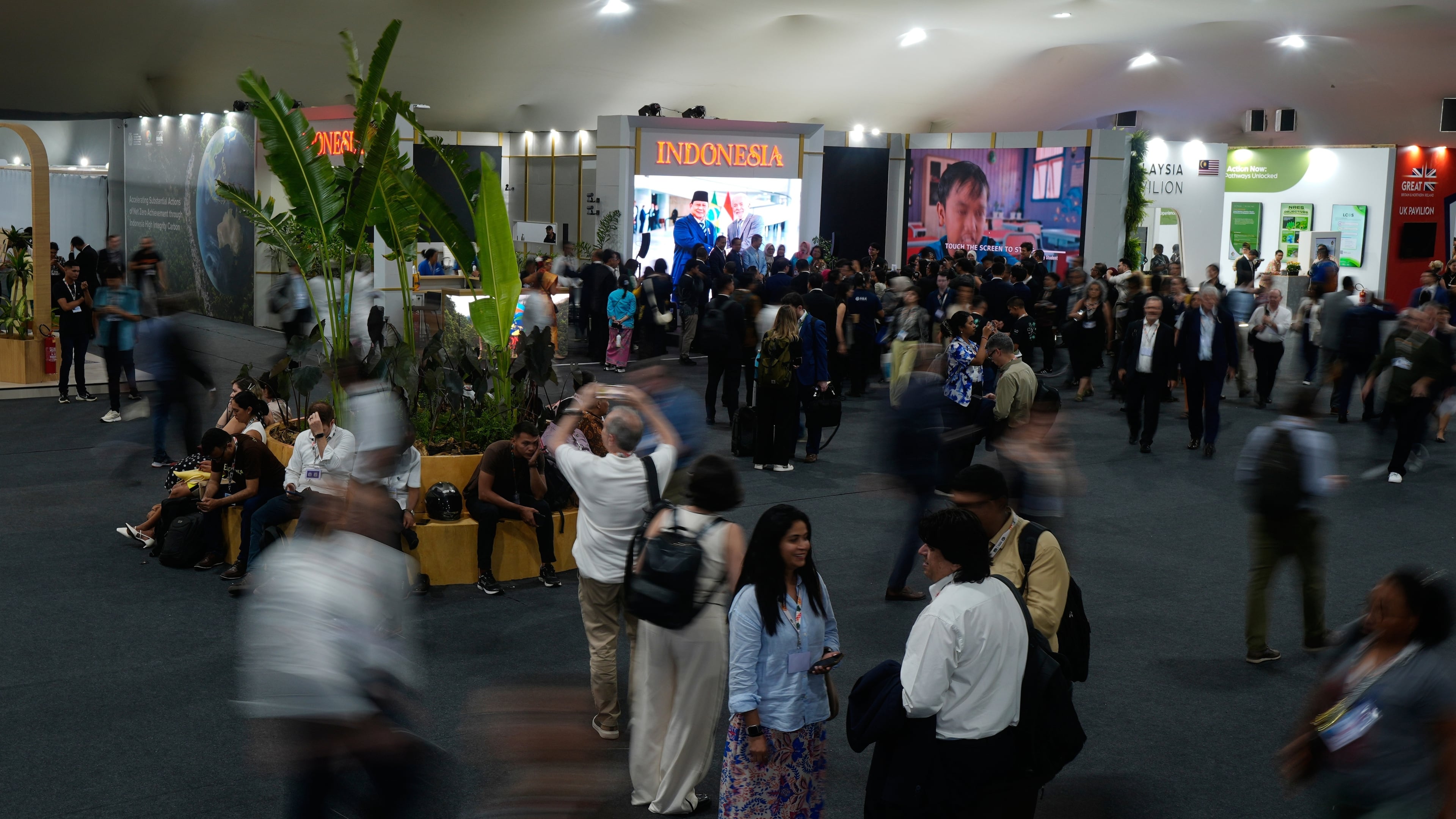 People walk outside the Indonesia Pavilion at the COP30 U.N. Climate Summit, Monday, Nov. 10, 2025, in Belem, Brazil. (AP Photo/Fernando Llano)