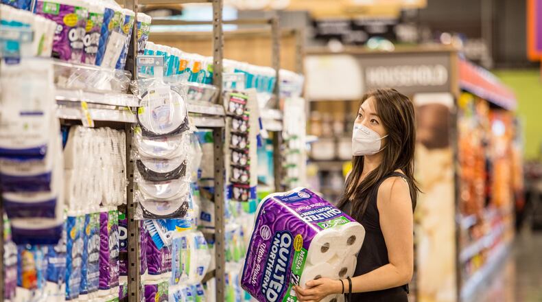 Alice Choe picks out paper goods on a full aisle in a Chamblee Kroger in September. An initial surge in buying and then heightened cleaning practices due to the coronavirus left paper towels in short supply from March to September. It took the industry about six months to catch up to demand. (Jenni Girtman for The Atlanta Journal-Constitution)