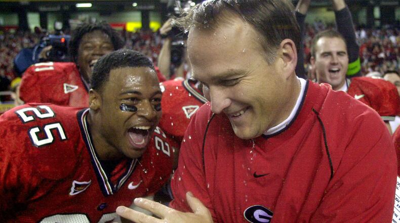 Georgia head coach Mark Richt celebrates with Michael Johnson (25) after he was doused with water as the Bulldogs beat Arkansas 30-3 in the SEC Championship at the Georgia Dome in Atlanta Saturday, Dec. 7, 2002. (AP Photo/John Bazemore)