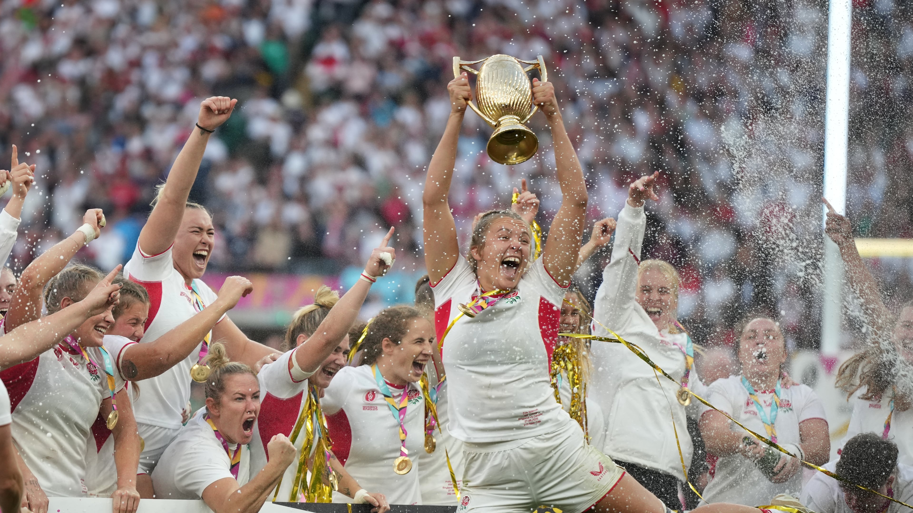 England's Zoe Aldcroft holds a trophy as she celebrates with her teammates after winning the Women's Rugby World Cup final match between England and Canada at the Allianz Stadium, Twickenham, London, Saturday, Sept. 27, 2025. (AP Photo/Alastair Grant)