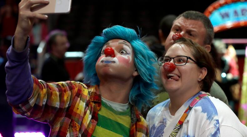 A Ringling Bros. and Barnum & Bailey clown takes a selfie with Jennifer and Kevin Fox, of Fort Pierce, Fla., during a pre show for fans Saturday, Jan. 14, 2017, in Orlando, Fla. The Ringling Bros. and Barnum & Bailey Circus will end the "The Greatest Show on Earth" in May, following a 146-year run of performances. Kenneth Feld, the chairman and CEO of Feld Entertainment, which owns the circus, told The Associated Press, declining attendance combined with high operating costs are among the reasons for closing. (AP Photo/Chris O'Meara)
