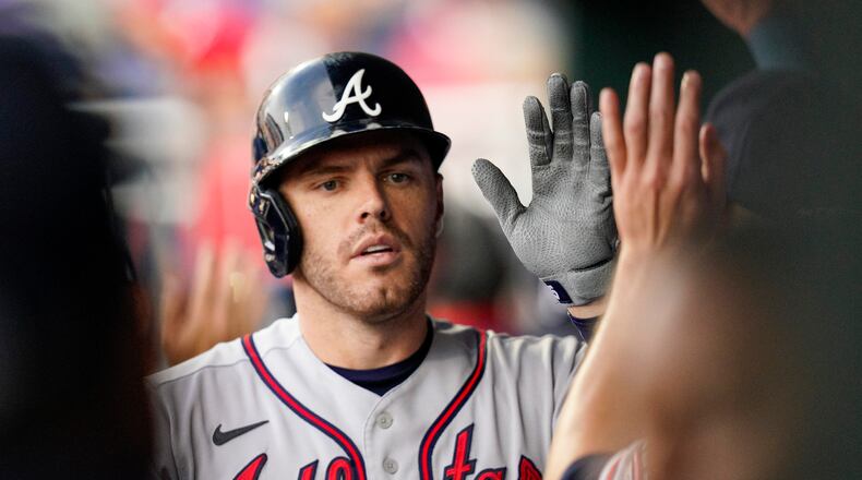 Atlanta Braves' Freddie Freeman is congratulated for his two-run home run during the first inning of the team's baseball game against the Philadelphia Phillies, Saturday, July 24, 2021, in Philadelphia. (AP Photo/Chris Szagola)