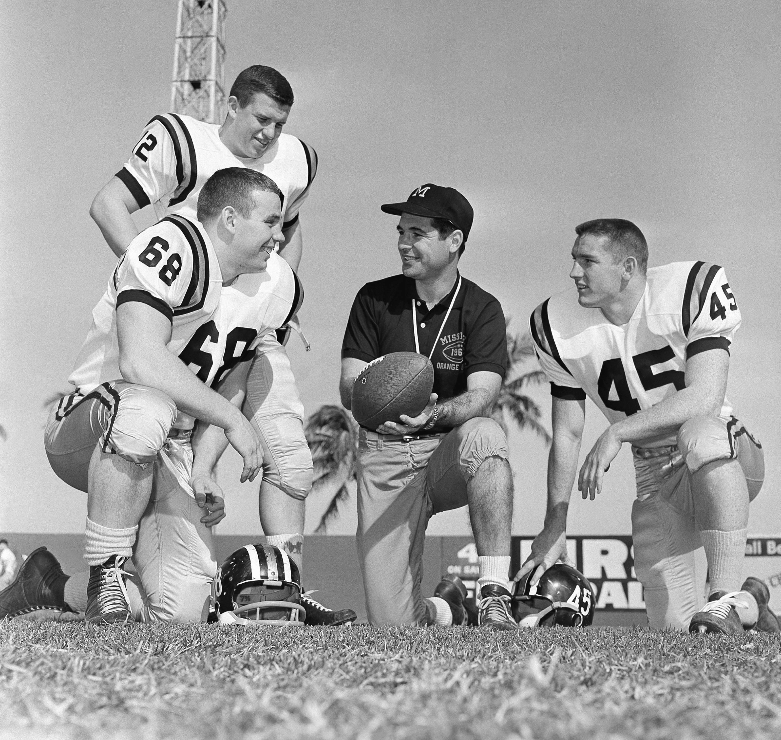 FILE - Missouri head coach Dan Devine, center, meets with three of his girders, Paul Henley (68), guard; Ron Tayler (12), quarterback; and Donnie Smith (45), halfback, in Miami on Dec. 27, 1960. (AP Photo/Earl Shugars, File)