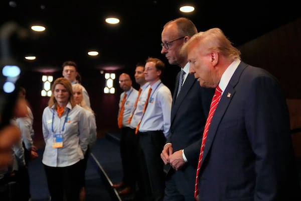 President Donald Trump, right, and Germany's Chancellor Friedrich Merz arrive for a plenary session at the NATO summit in The Hague, Netherlands, Wednesday, June 25, 2025. (AP Photo/Matthias Schrader)