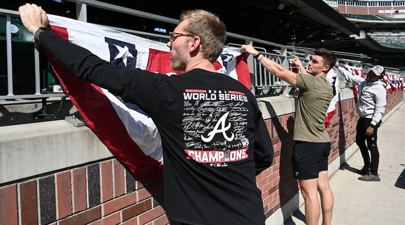 October 7, 2022 Atlanta - From left, Evan Foertsch, Bruce Stephens and Clayton Rounsaville install flag buntings prior to National League Division Series (NLDS) starting next Tuesday at Truist Park on Friday, October 7, 2022. (Hyosub Shin / Hyosub.Shin@ajc.com)