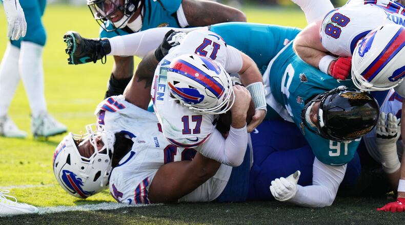 Buffalo Bills quarterback Josh Allen (17) pushes in for a first down as Jacksonville Jaguars defensive tackle Arik Armstead (91) tries to stop him during the second half of an NFL wild-card playoff football game Sunday, Jan. 11, 2026, in Jacksonville, Fla. (AP Photo/Chris O'Meara)