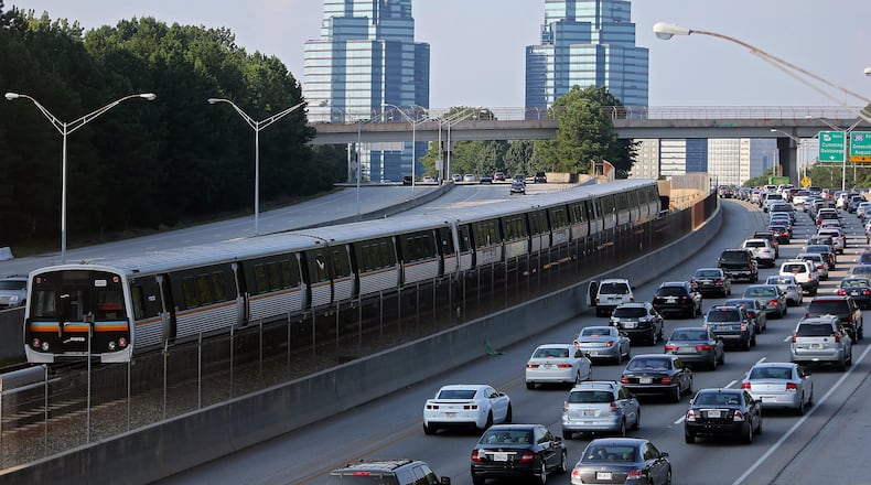A MARTA train makes its way North past Ga. 400 traffic. Fulton County is considering expanded transit services. BEN GRAY / AJC FILE PHOTO