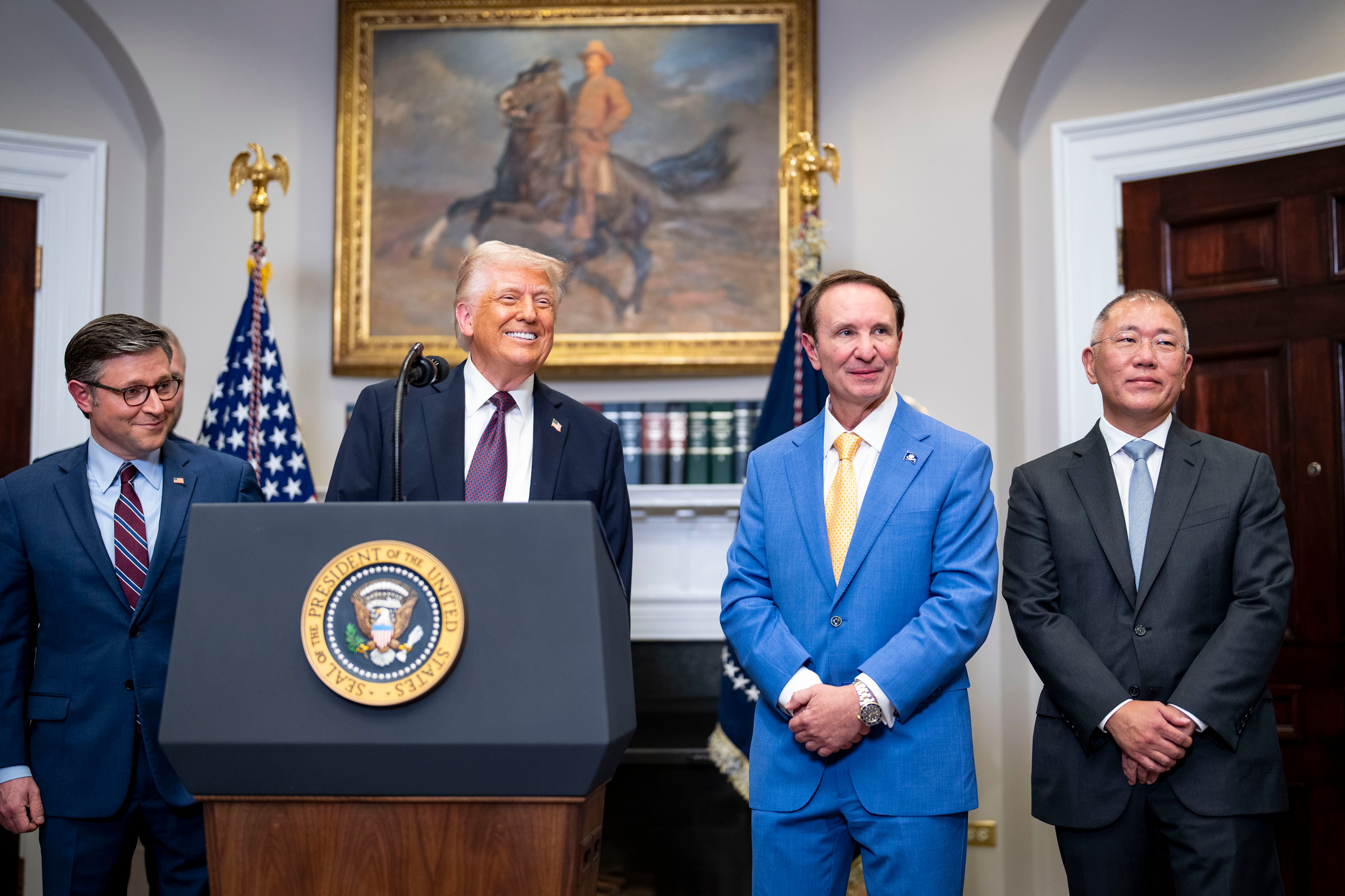 President Donald Trump (center, at lectern) delivers remarks about plans for a new steel factory in Louisiana at the White House in March. Looking on, from right, are Euisun Chung, executive chairman of Hyundai Motor Group; Gov. Jeff Landry of Louisiana; and House Speaker Mike Johnson (R-La.). Hyundai Motor Corp. said it will invest $20 billion to expand manufacturing in the United States in what Trump said was proof that his tariff policies are creating jobs. (Doug Mills/The New York Times)