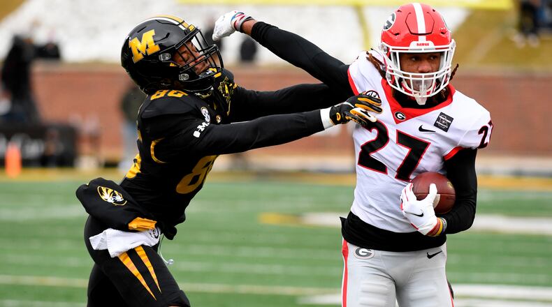 Georgia cornerback Eric Stokes (27) runs with the ball after intercepting a pass intended for Missouri wide receiver Tauskie Dove (86) in the Bulldogs' last game. The redshirt junior is among at least four UGA players who are opting out of Friday's Peach Bowl game against Cincinnati. (L.G. Patterson/AP)