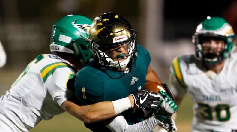 In the Sept. 28, 2017 photo, Knoxville Catholic's Dashon Bussell is hit by Rhea County's Reece Cooley, left, during a high school football game in Knoxville, Tenn. Bussell says he has not decided whether he plans to sign with his school in December or wait until February. The Western Michigan-bound receiver likes having the option. The high school senior has that choice thanks to a new set of NCAA recruiting rules that took effect this year. (Wade Payne/Knoxville News Sentinel via AP)