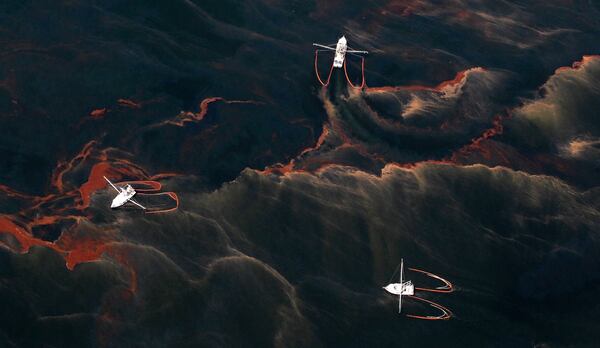FILE - Shrimp boats are used to collect oil with booms in the waters of Chandeleur Sound, La., May 5, 2010. (AP Photo/Eric Gay, File)