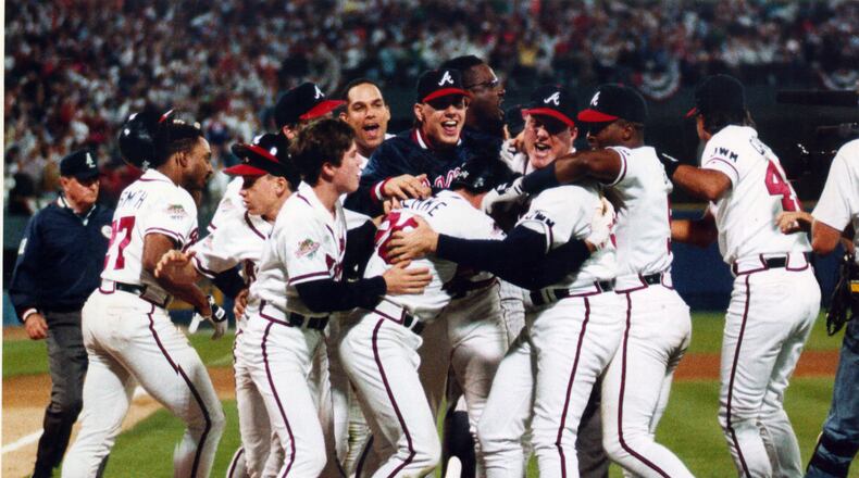 Braves players surround Mark Lemke after he scored the winning run in the ninth inning to beat Minnesota in Game 4 of the 1991 World Series, evening the series at two games each. (Frank Niemer / AJC)