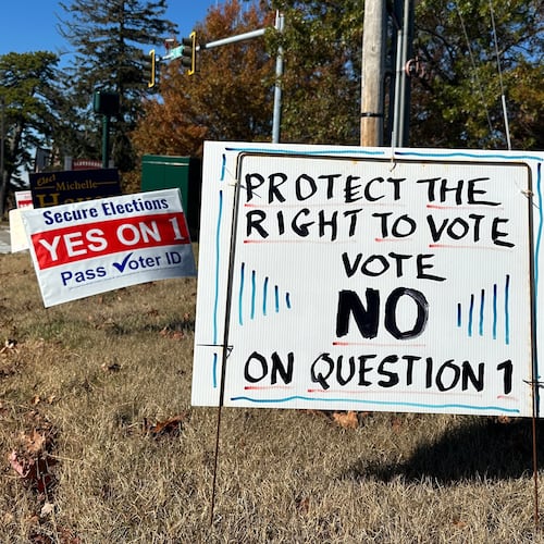 Signs supporting and opposing a voter identification referendum in the state are shown Thursday, Oct. 23, 2025, in Scarborough, Maine. (AP Photo/Patrick Whittle)