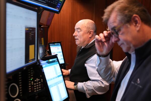 People work on the floor at the New York Stock Exchange in New York, Monday, March 31, 2025. (AP Photo/Seth Wenig)
