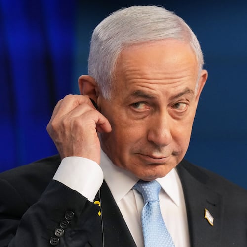 Israeli Prime Minister Benjamin Netanyahu adjusts the headphones during a joint press conference with German Chancellor Friedrich Merz in Jerusalem Sunday, Dec. 7, 2025. (AP Photo/Ariel Schalit, Pool)