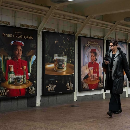 A person walks past posters promoting the campaign by Bath & Body Works at Grand Central station, Wednesday, Nov. 19, 2025, in New York. (AP Photo/Yuki Iwamura)