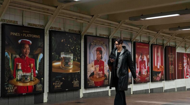 A person walks past posters promoting the campaign by Bath & Body Works at Grand Central station, Wednesday, Nov. 19, 2025, in New York. (AP Photo/Yuki Iwamura)