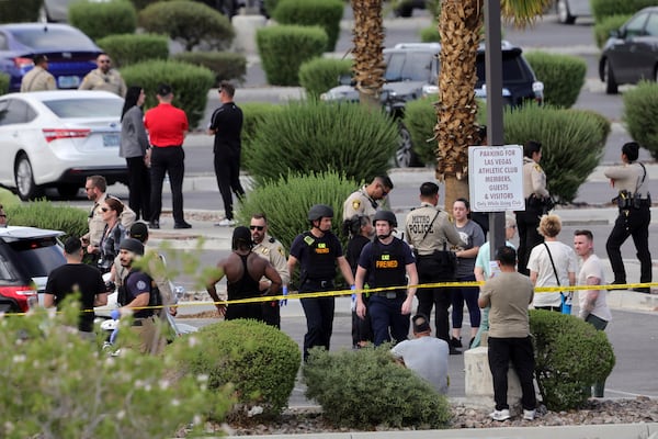 Las Vegas Metro Police officers talk with gym members after a shooting at a Las Vegas Athletic Club Friday, May 16, 2025, in Las Vegas. (Steve Marcus/Las Vegas Sun via AP)