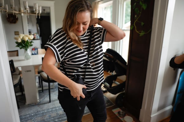 Tessa Horehled puts on a wearable sensor that will test air quality around her on Tuesday, Aug. 5, 2025. (Natrice Miller/AJC)