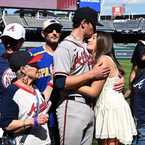 Atlanta Braves starting pitcher JR Ritchie, left center, hugs his fiancée Makena Miller after winning his major league debut baseball game against the Washington Nationals, Thursday, April 23, 2026, in Washington. (AP Photo/Nick Wass)