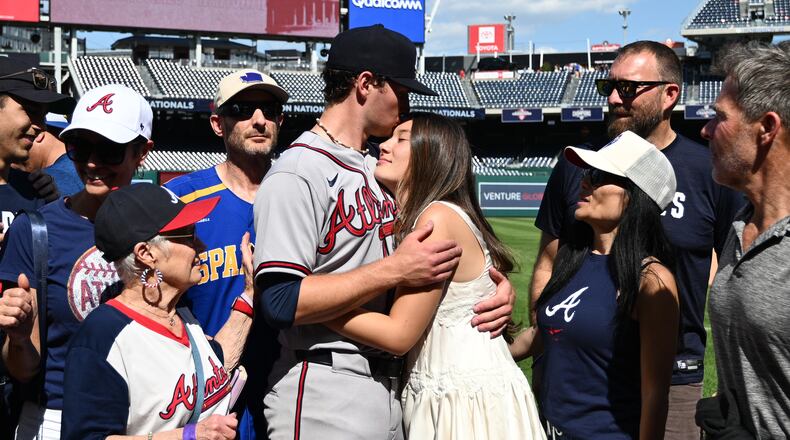 Atlanta Braves starting pitcher JR Ritchie, left center, hugs his fiancée Makena Miller after winning his major league debut baseball game against the Washington Nationals, Thursday, April 23, 2026, in Washington. (AP Photo/Nick Wass)