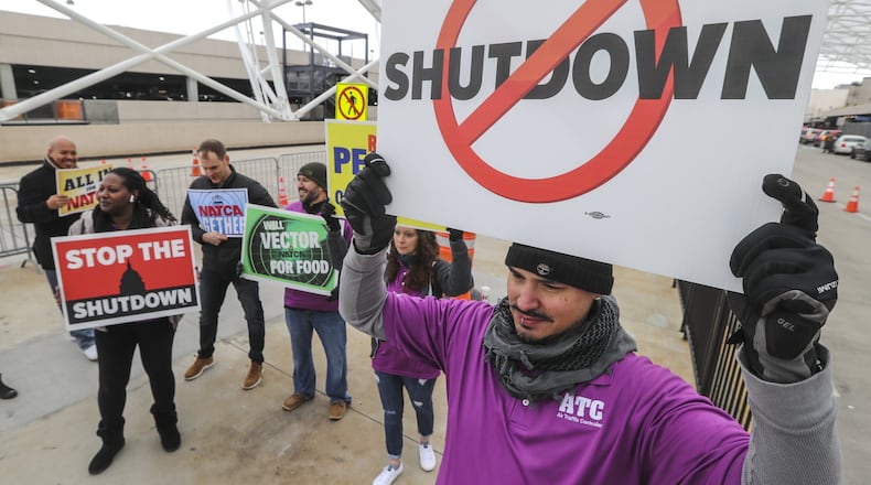 Air traffic controller, Rafael Naveira (right) and fellow controllers rallied at Hartsfield-Jackson International Airport on Jan. 14 calling for an end to the federal shutdown. JOHN SPINK/JSPINK@AJC.COM