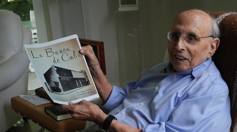 Raul Valdes-Fauli holds a picture of the family-owned Pedroso Bank in Havana during an interview Tuesday, April 21, 2026, in Coral Gables, Fla. (AP Photo/Marta Lavandier)