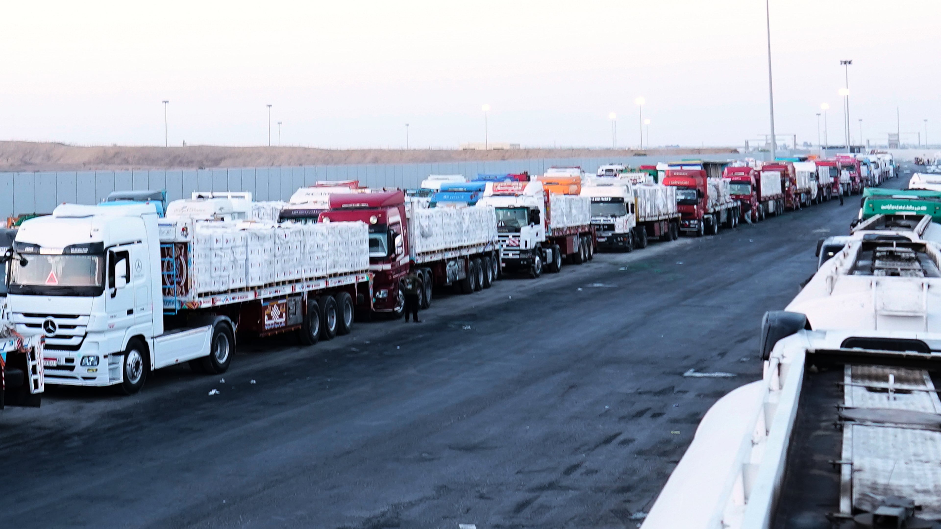 FILE -Trucks carrying humanitarian aids prepare to cross the Egyptian gate of the Rafah crossing, waiting for inspections by Israeli authorities before entering the Gaza Strip, following an agreement between Israel and Hamas on a ceasefire, Oct. 20, 2025. (AP Photo/Mohamed Arafat, File)