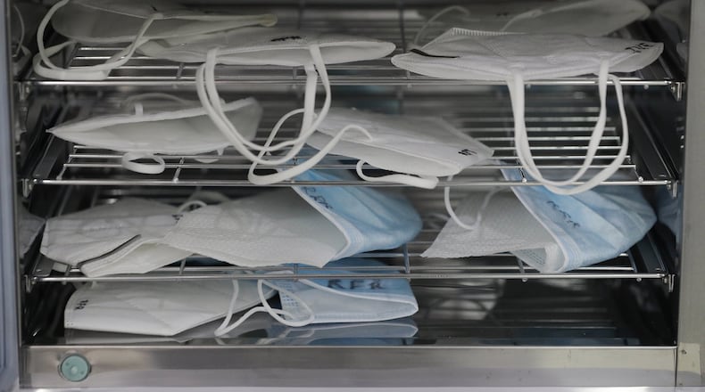 Used face masks are sanitized inside a UV sterilizer so they can be worn again by dentists to prevent the spread of COVID-19 at a clinic in Manila, Philippines on Monday, July 6, 2020. Mask-wearing is seen as critical to flattening the curve of coronavirus infections. (AP Photo/Aaron Favila)