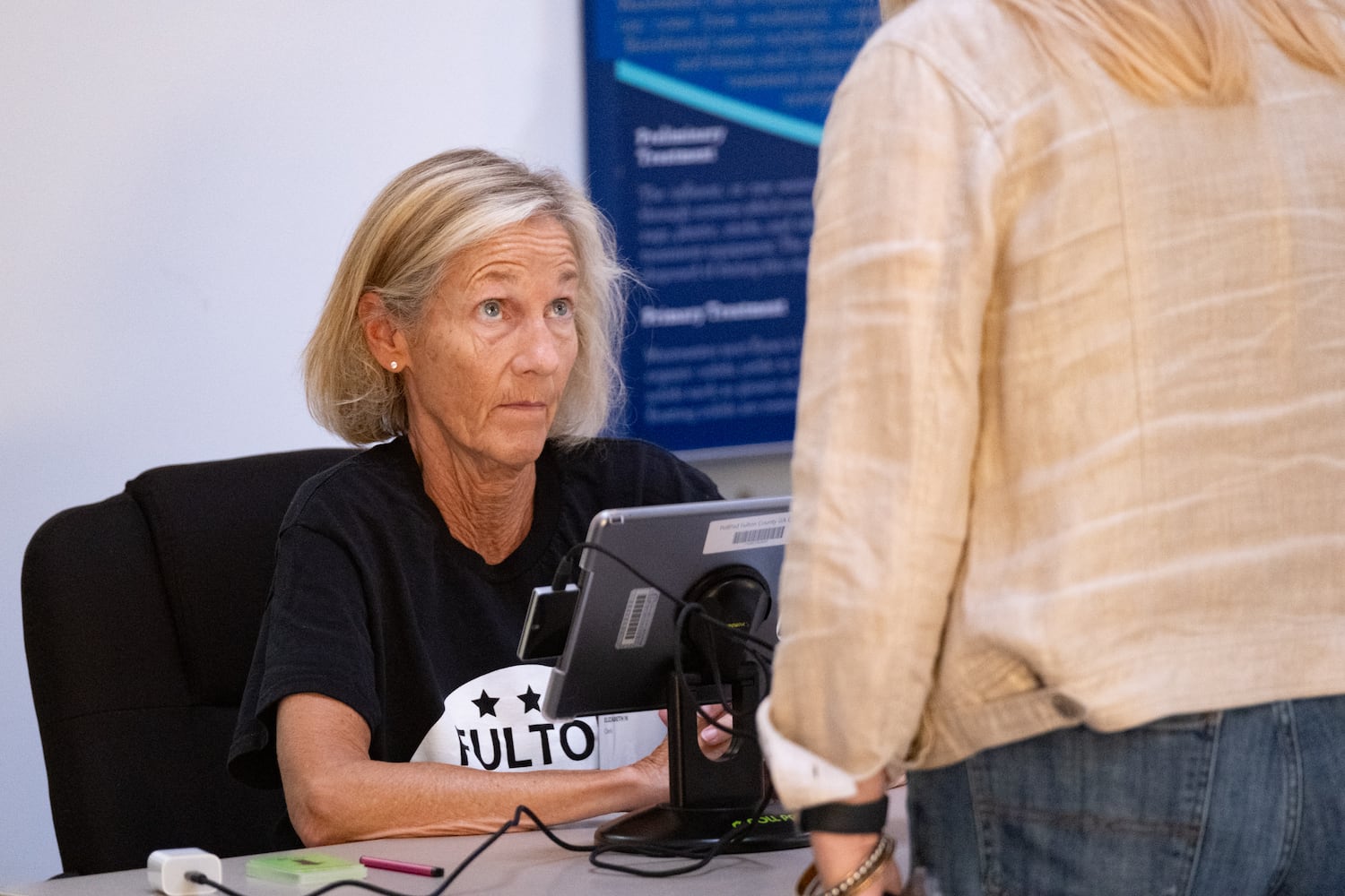 A poll worker checks a voter in at the Johns Creek Environmental Campus in Alpharetta on Tuesday, May 19, 2026. (Ben Gray for the AJC)