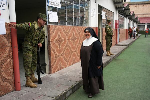 A soldier directs a nun to her polling station during the presidential election runoff in Quito, Ecuador, Sunday, April 13, 2025. (AP Photo/Carlos Noriega)