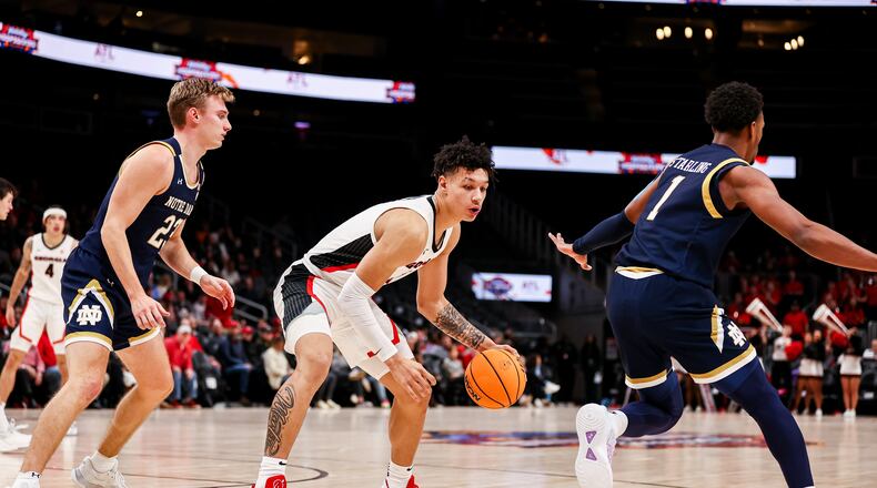 Georgia forward KyeRon Lindsay (2) dribbles between two Notre Dame defenders during their Holiday Hoopsgiving game at State Farm Arena in Atlanta on Dec. 18, 2022. (Photo by Tony Walsh/UGA Athletics)
