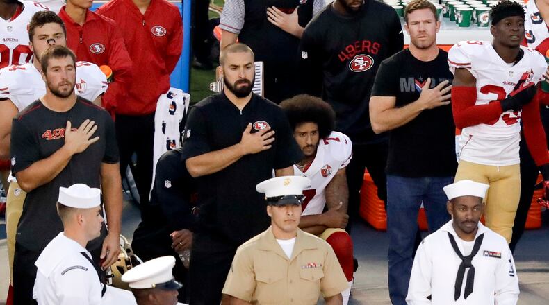 FILE - In this Thursday, Sept. 1, 2016, file photo, San Francisco 49ers quarterback Colin Kaepernick, center, kneels during the national anthem before an NFL preseason football game against the San Diego Chargers in San Diego. With Case Keenum and Blaine Gabbert set as starting quarterbacks, Kaepernick's refusal to stand for the anthem getting more public acceptance and the Rams mostly settled into their new home, much of the focus when the teams open the season on Monday night will be on the running backs. (AP Photo/Chris Carlson, File)