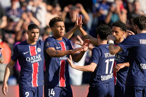 PSG's Desire Doue, centre, celebrates after scoring his side's opening goal during the French League One soccer match between Paris Saint-Germain and Angers at Parc des Princes stadium in Paris, Saturday, April 5, 2025. (AP Photo/Michel Euler)