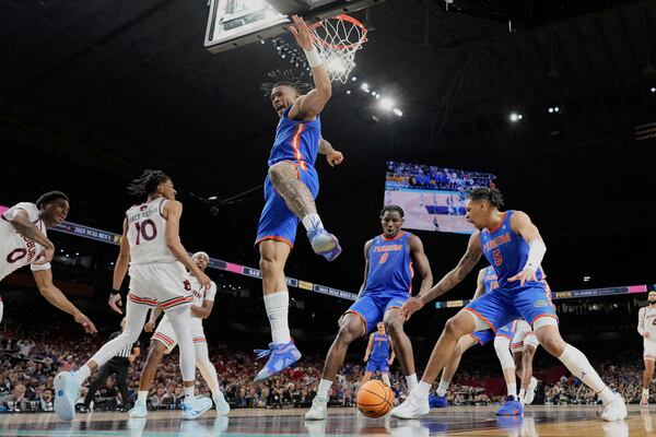 Florida's Alijah Martin, center, lands after dunking the ball against Auburn during the second half in the national semifinals at the Final Four of the NCAA college basketball tournament, Saturday, April 5, 2025, in San Antonio. (AP Photo/Eric Gay)